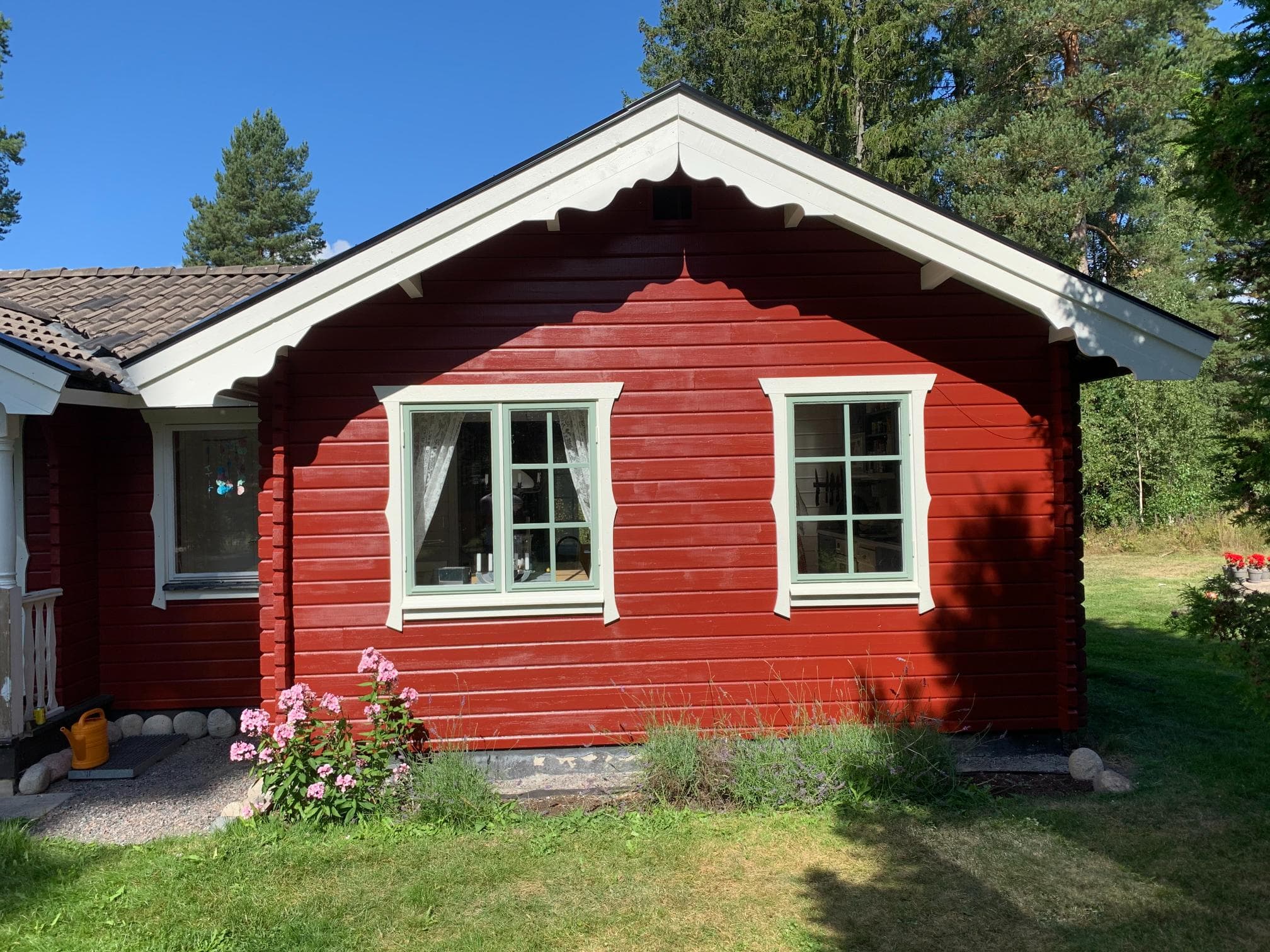 Efter fasadrenovering – välmålad träpanel på husvägg