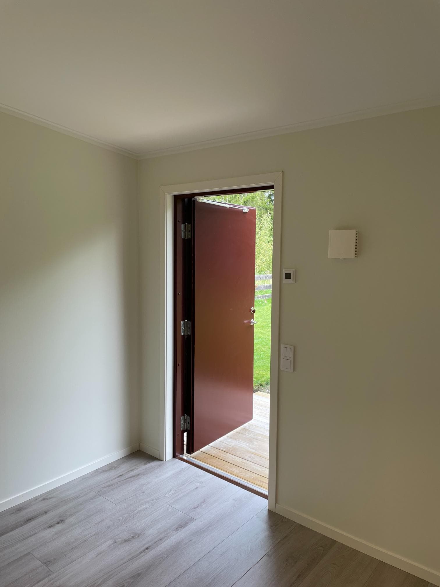 Efter fasadrenovering – fräscht målat trä runt entré